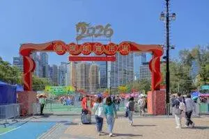 Crowds enjoying the vibrant 2026 Lunar New Year Fair at Victoria Park, Hong Kong under clear blue skies.