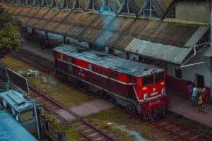 A red train captured at Yangon Railway Station with a classic, vintage vibe, showcasing local life.