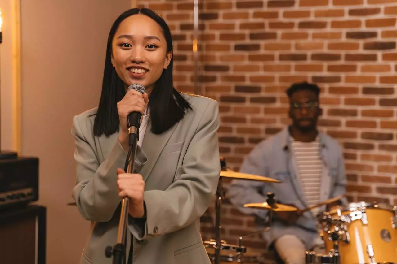 Asian female vocalist performing with a microphone representing Myanmar popular music artists and hit songs in 2026