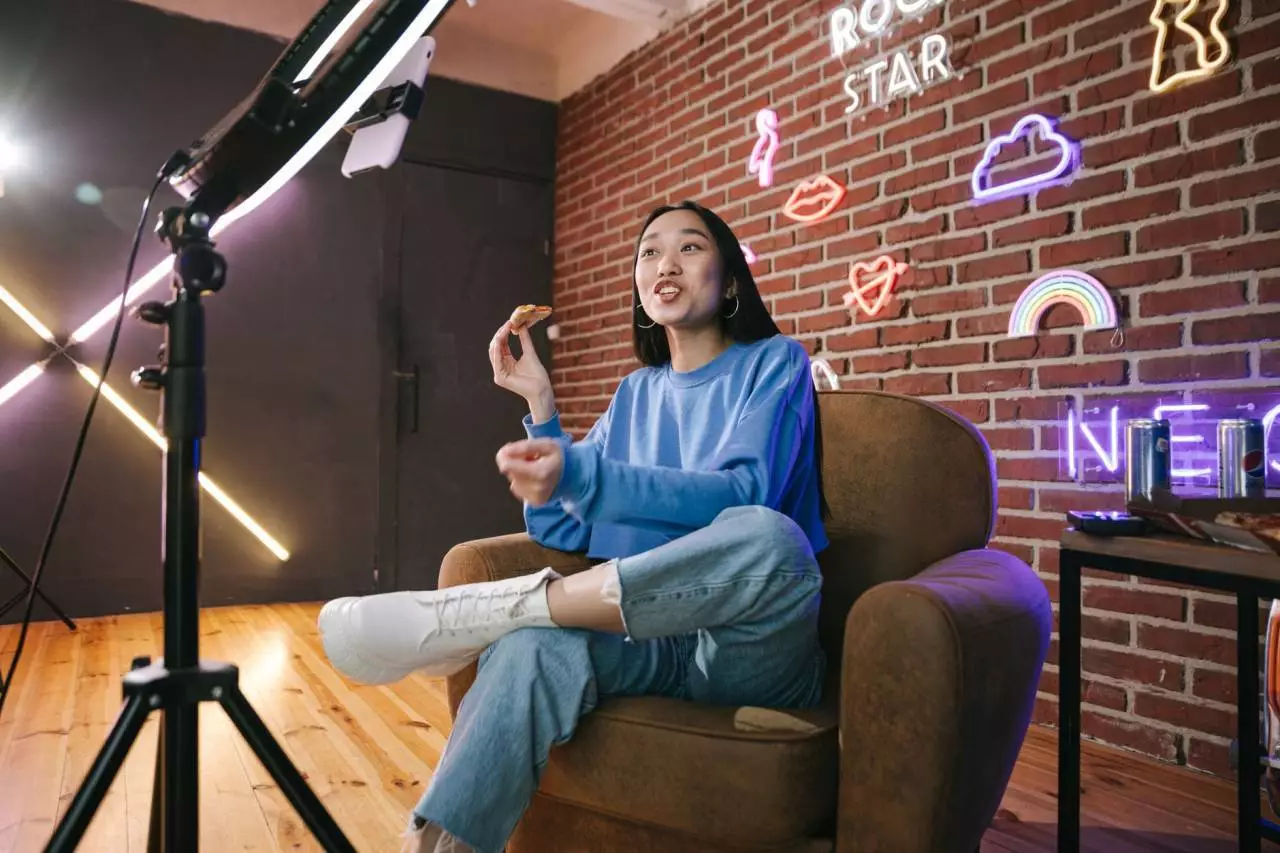 Young Asian woman streaming live content with neon lights representing top Myanmar YouTube influencers in 2026